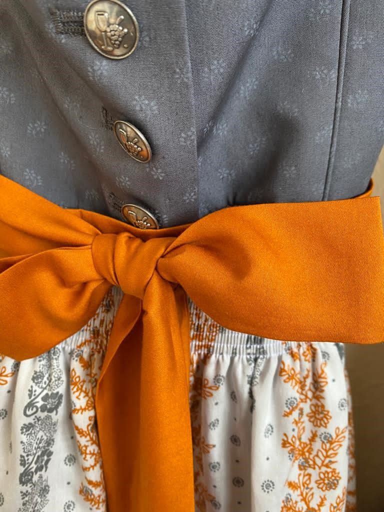 Der Blick fällt auf die orange Schleife eines Weinviertel-Dirndls.