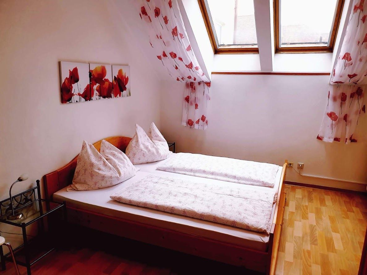 Cozy bedroom with double bed, skylights and poppy decor.