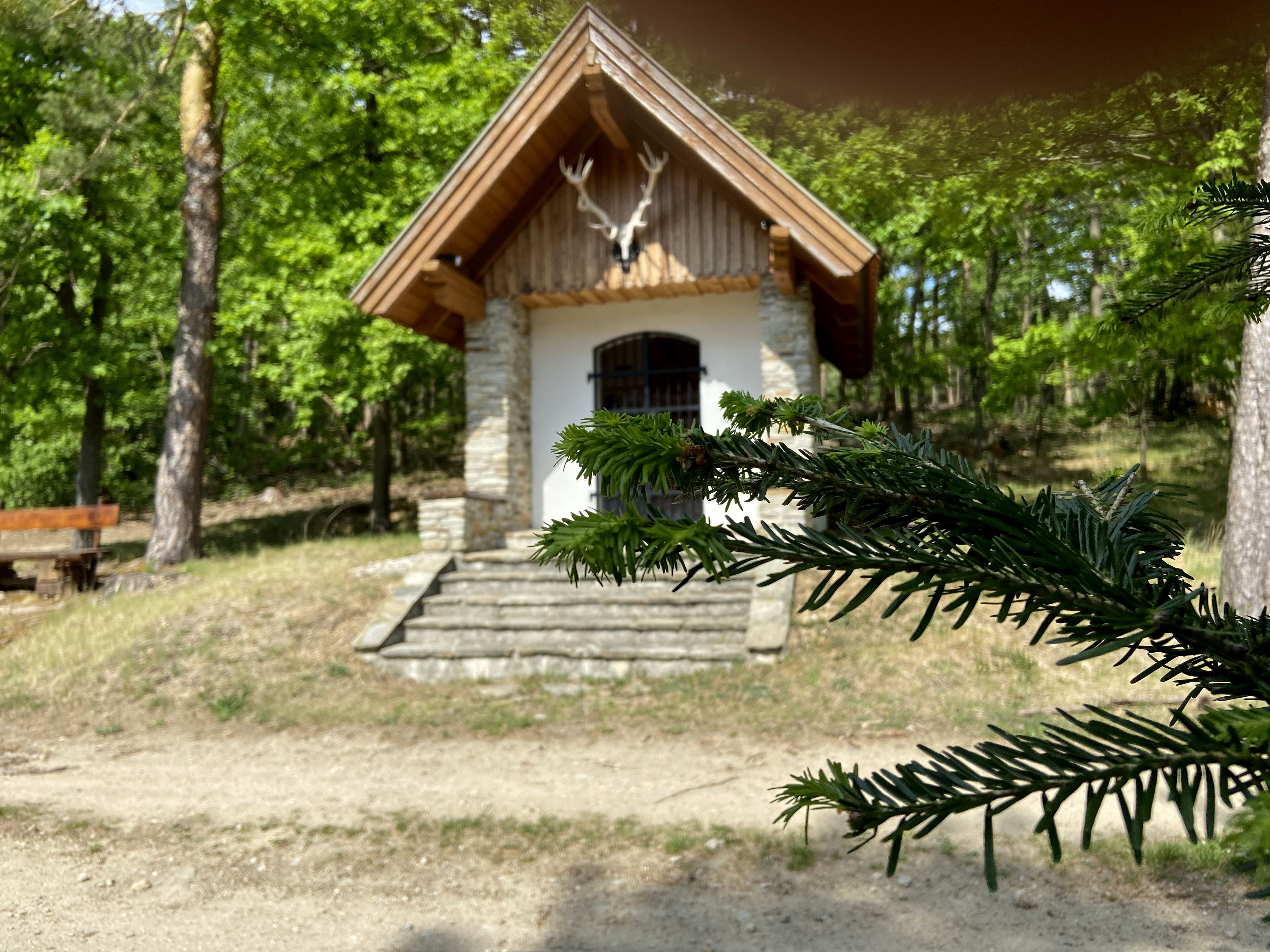 Kleine Kapelle im Wald mit Hirschgeweih über dem Eingang.