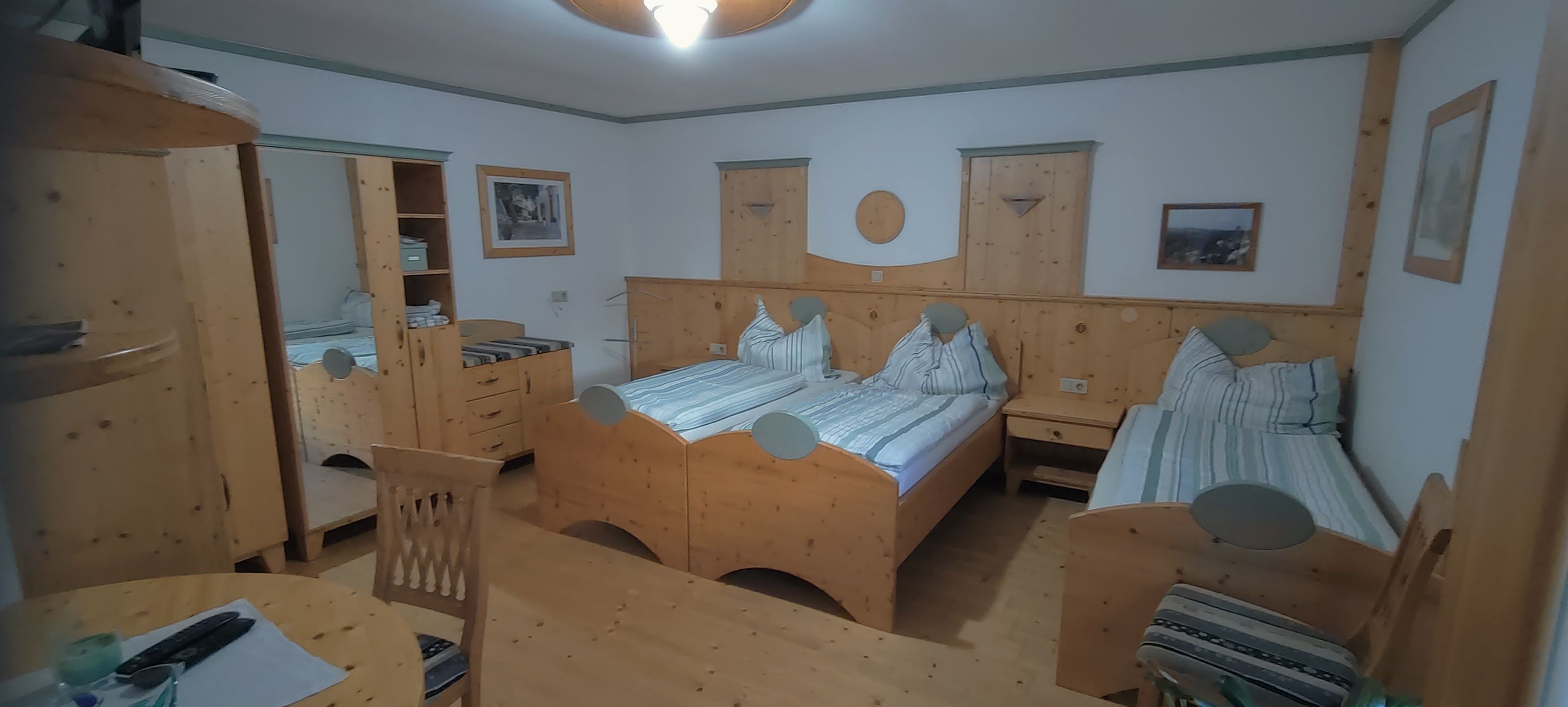 Gemütliches Doppelzimmer mit Holzmöbeln und zwei Einzelbetten.