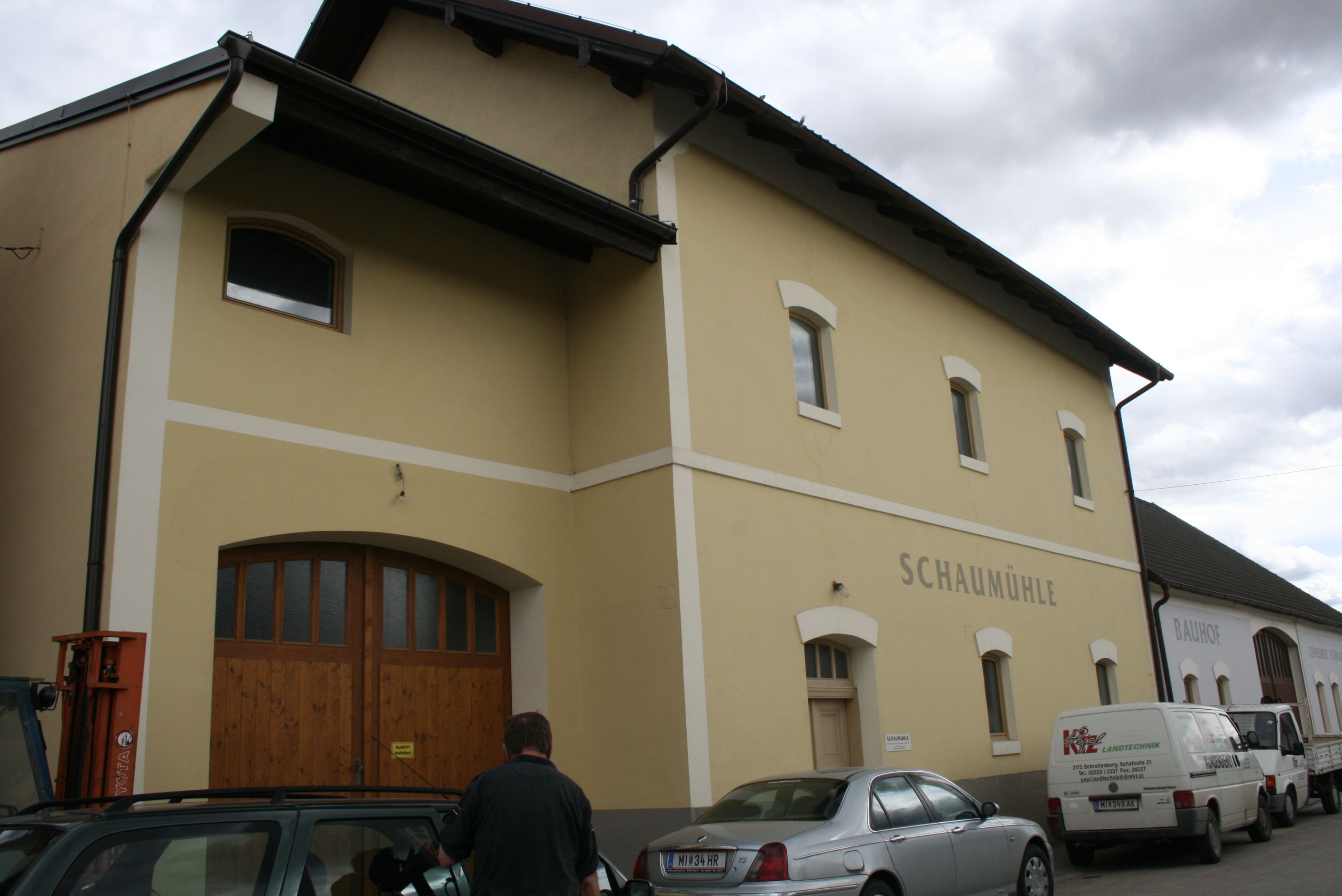 Außenansicht eines gelben Gebäudes mit der Aufschrift 'Schaumühle'.