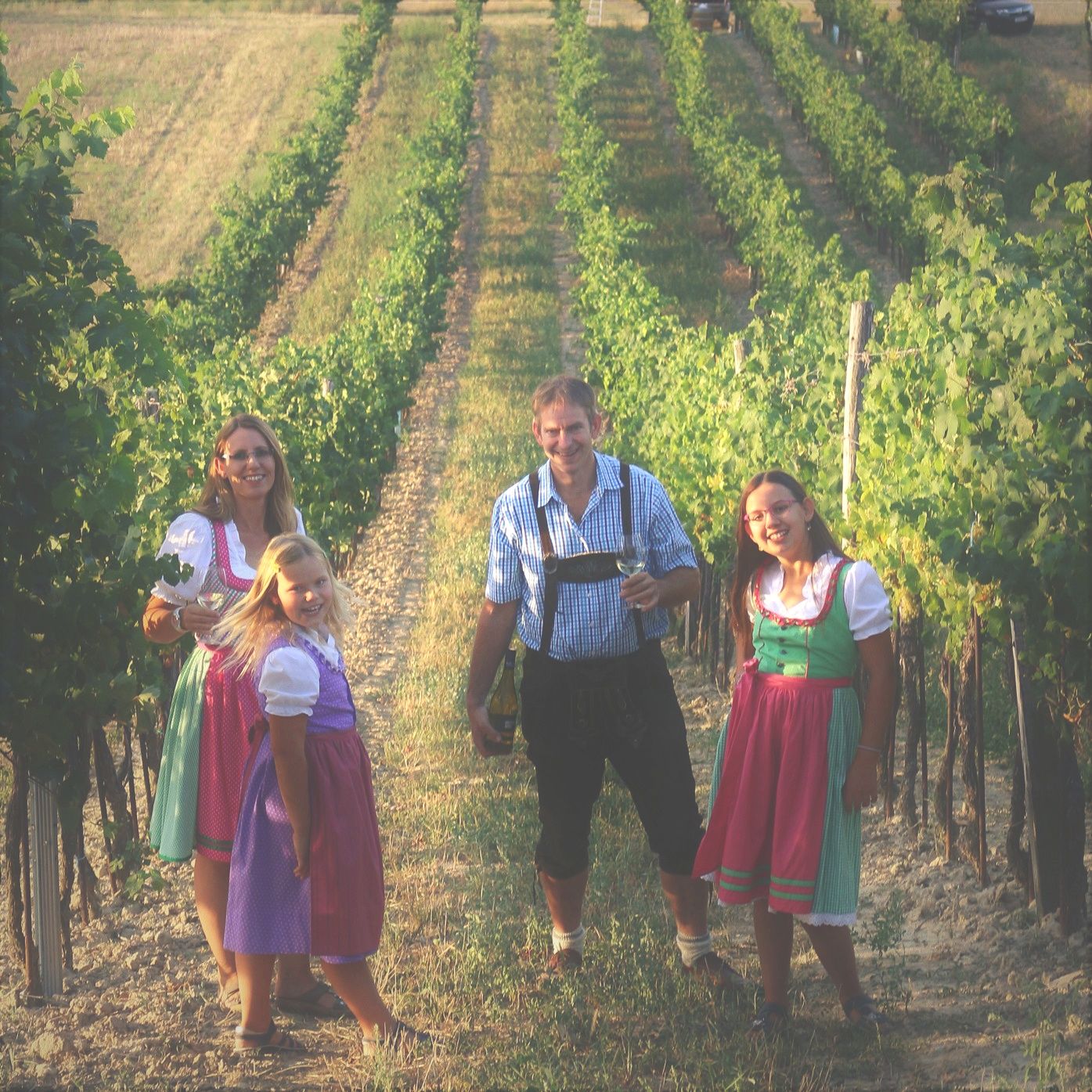 Family in traditional dress in a vineyard.