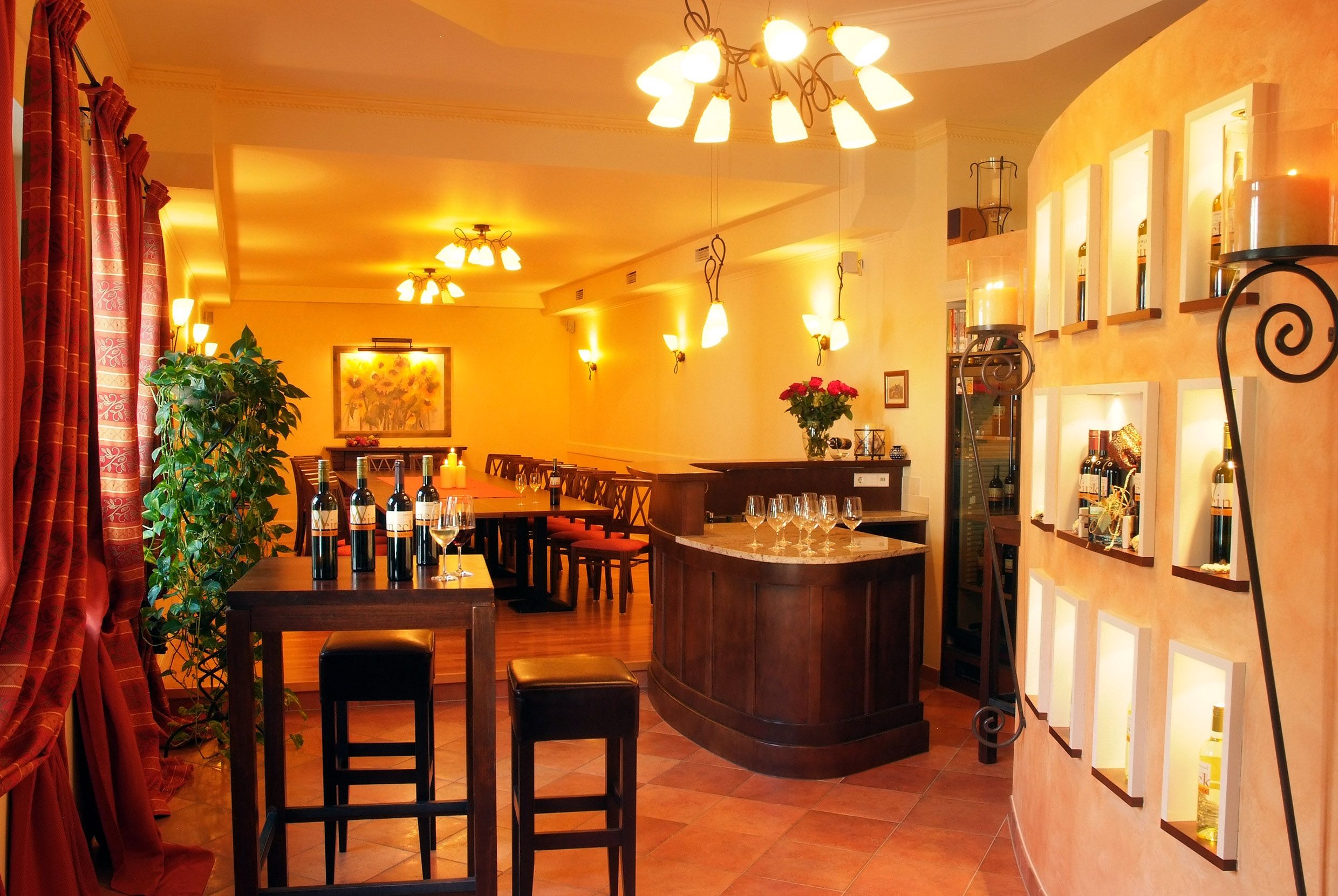 Ein eleganter Verkostungsraum mit Weinflaschen, Gläsern und stilvoller Beleuchtung.