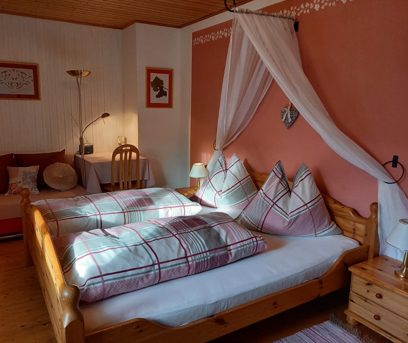 Gemütliches Gästezimmer mit Doppelbett, Nachttischlampen und Schreibtisch.