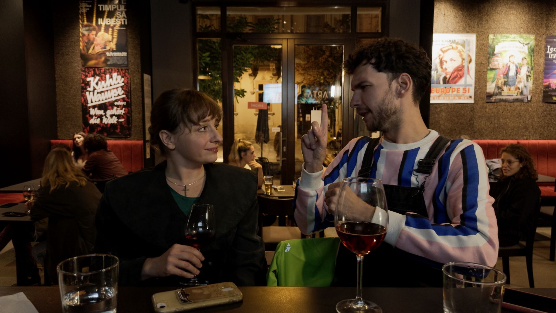 Eine Person und eine Person, die an einem Tisch mit Weingläsern sitzen