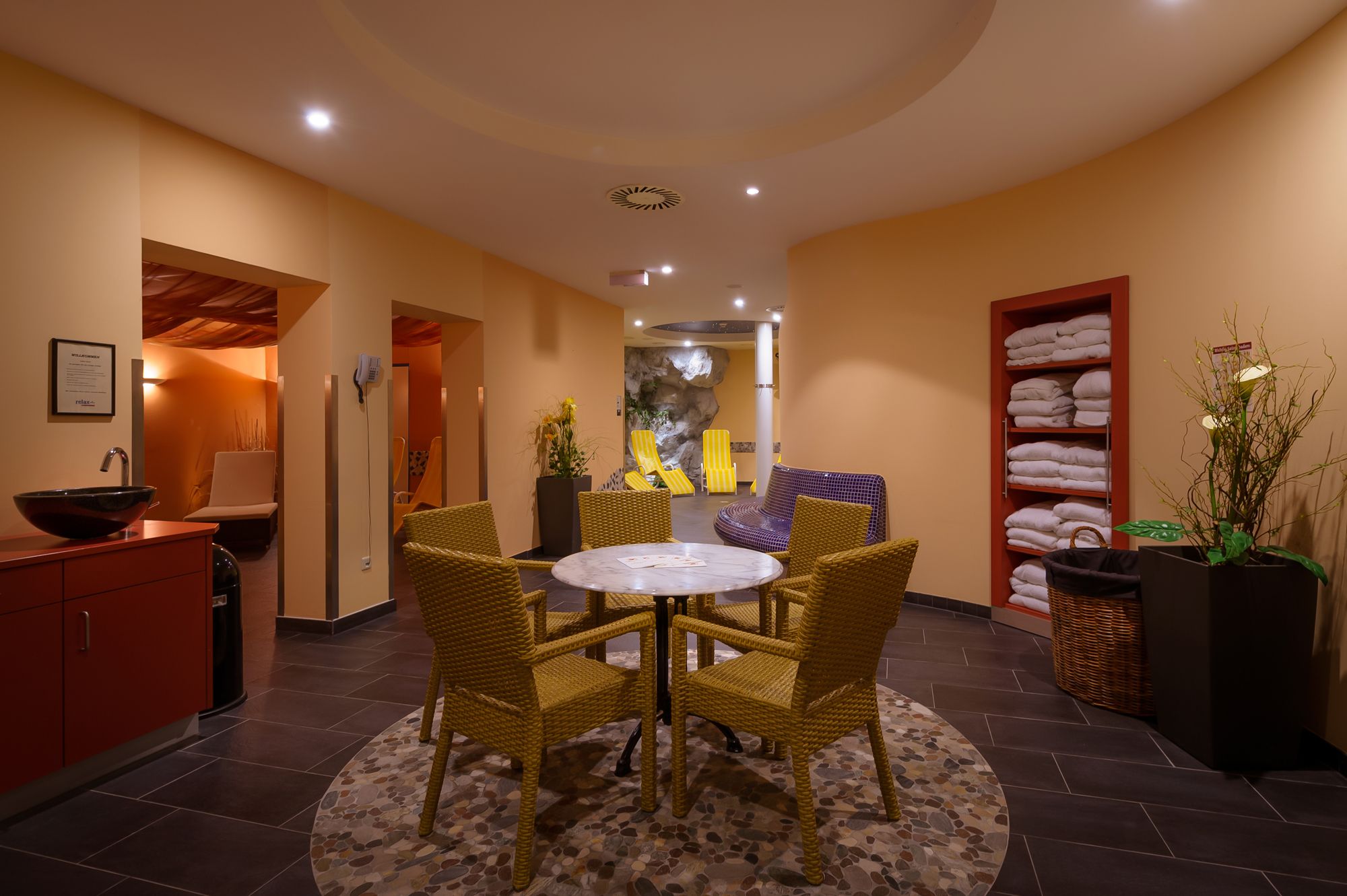 Wellnessbereich eines Hotels mit Tisch, Stühlen und Liegen.