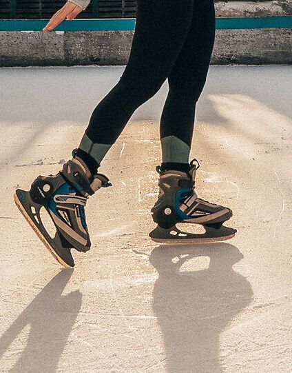 Ein strahlender Wintertag lädt zum Eislaufen ein, während die Sonne sanft über den schimmernden Eisplatz scheint. Die frische, kalte Luft und das Lachen der Schlittschuhfahrer schaffen eine fröhliche Atmosphäre, die die Schönheit der Wiener Alpen umrahmt.