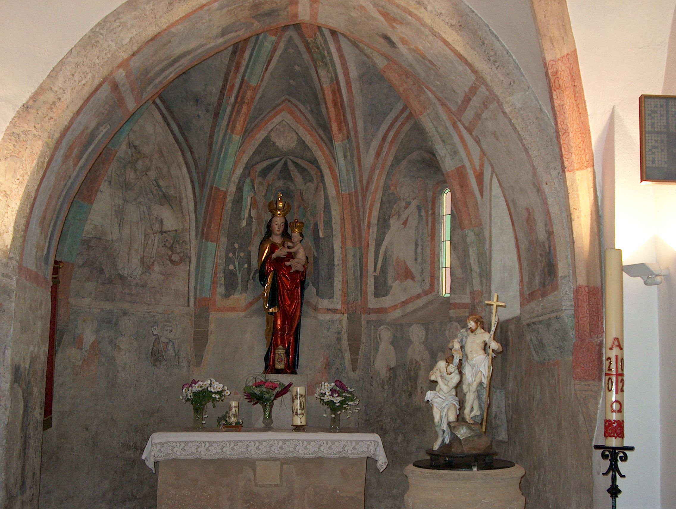 Innenansicht einer Kapelle mit Fresken und Statuen.