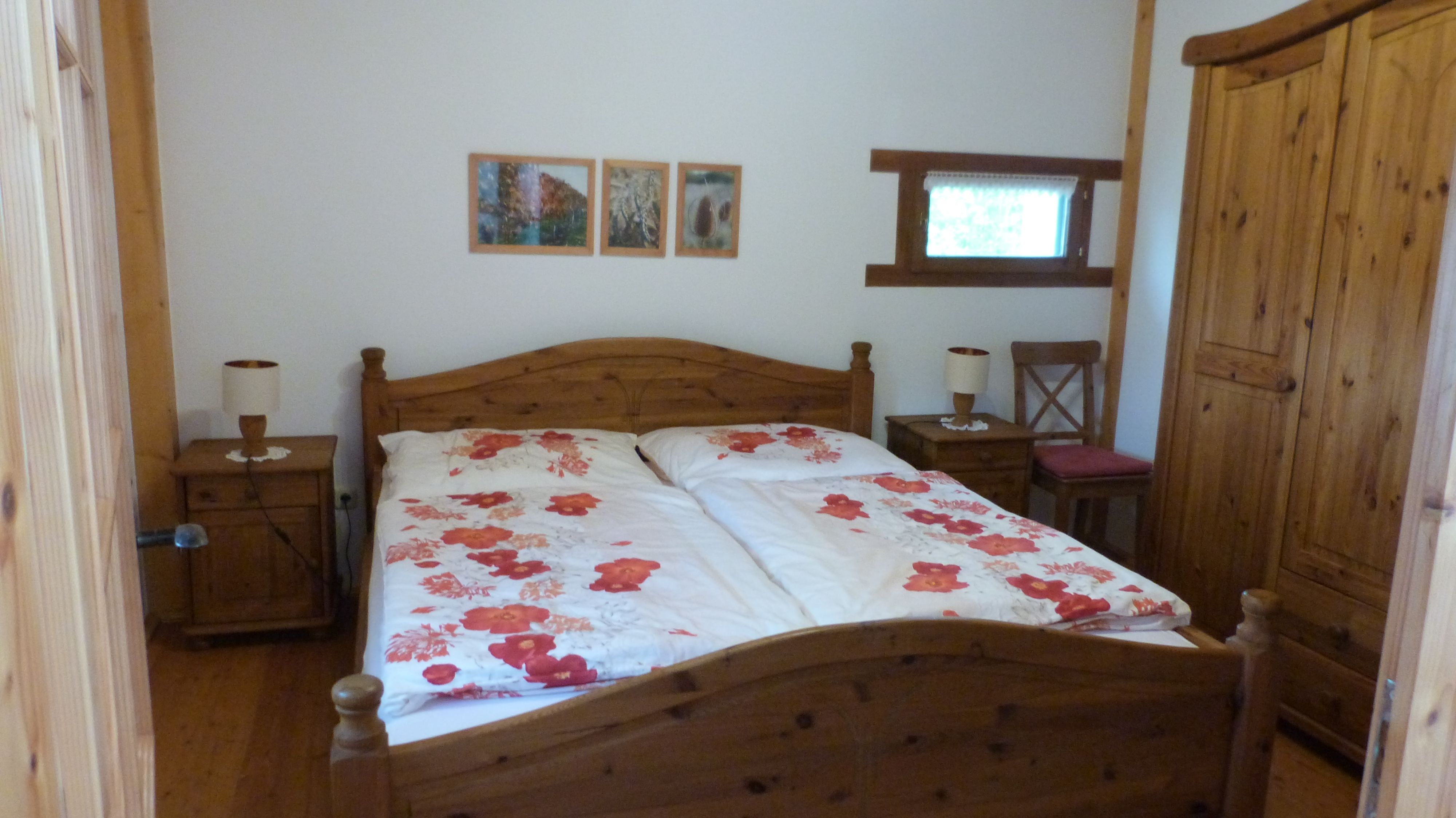 Ein gemütliches Schlafzimmer mit Holzmöbeln und einem Doppelbett mit Blumenbettwäsche.