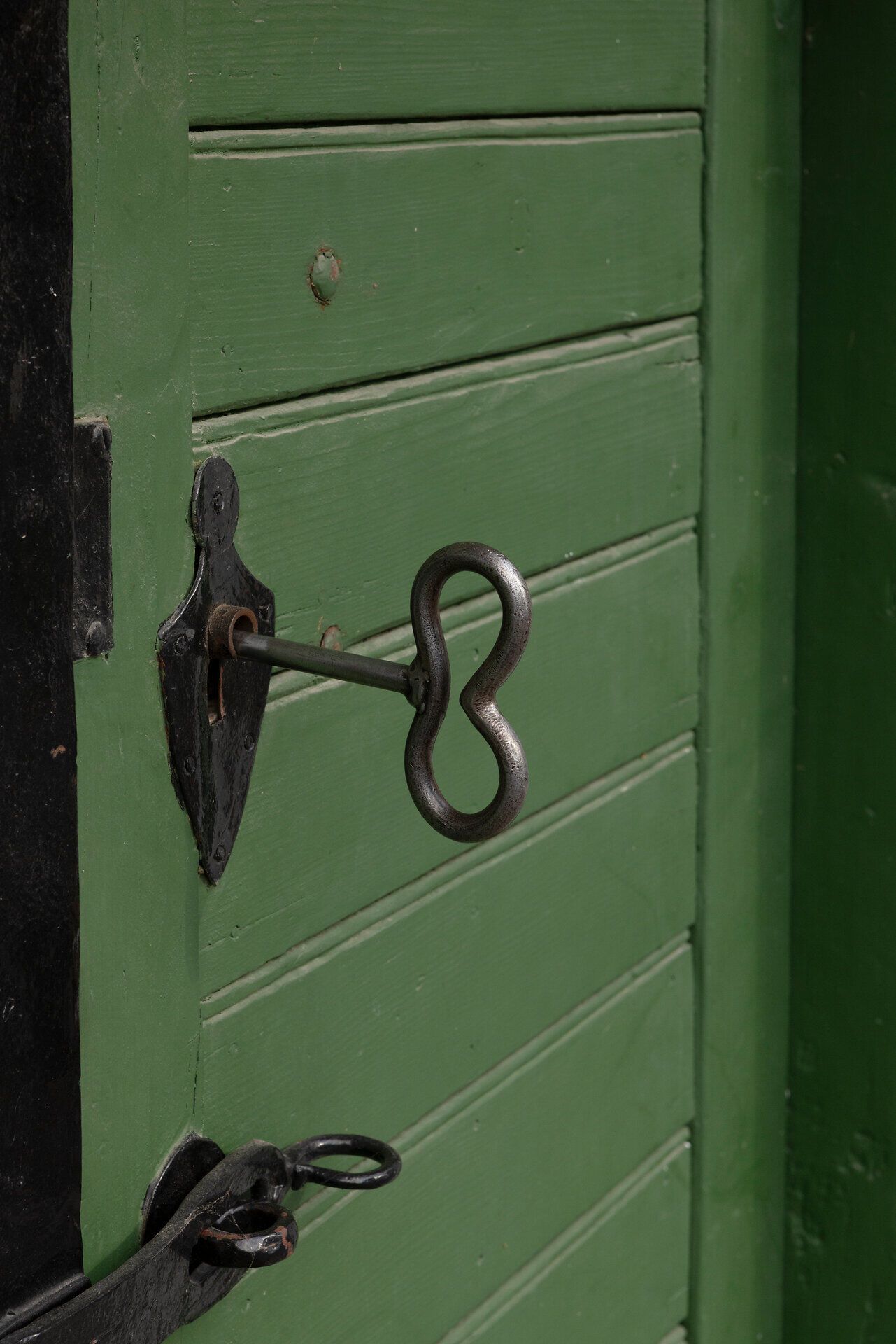 Eine alte, grüne Tür mit einem kunstvoll gestalteten Schlüssel, der bereit ist, neue Abenteuer zu öffnen. Die rustikale Atmosphäre lädt dazu ein, die Geheimnisse hinter dieser Tür zu entdecken und die Schönheit der Umgebung zu genießen.