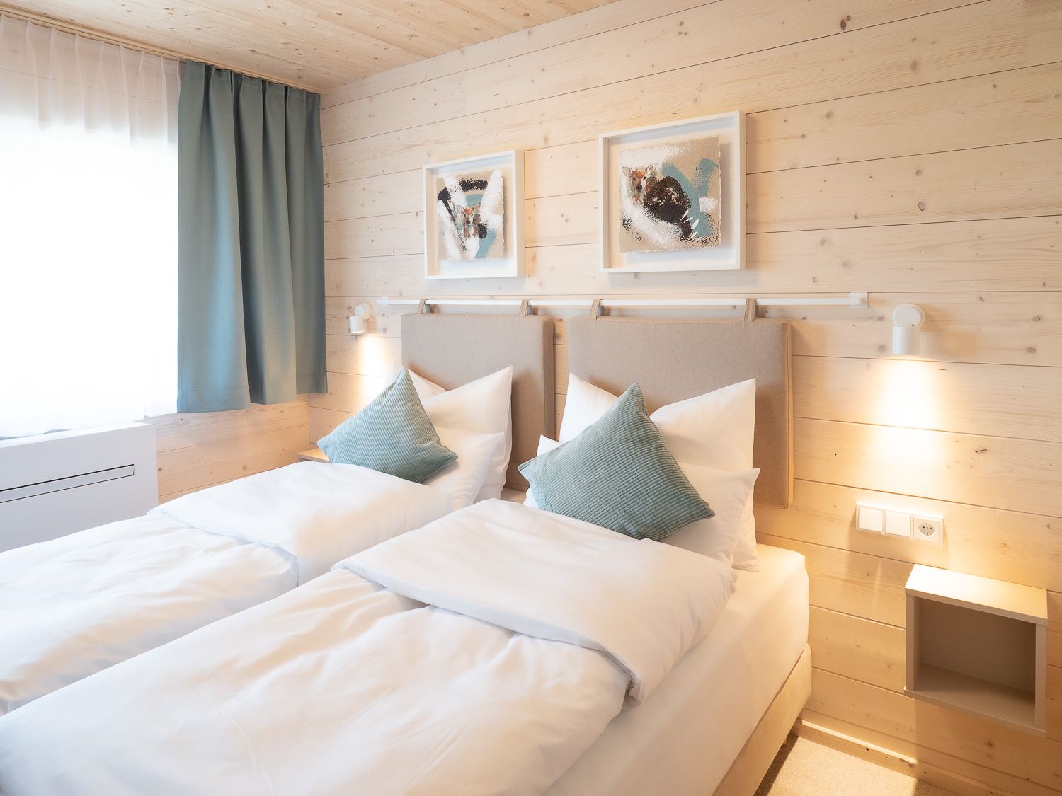 Gemütliches Doppelzimmer mit zwei Einzelbetten, Holzwänden und moderner Dekoration.