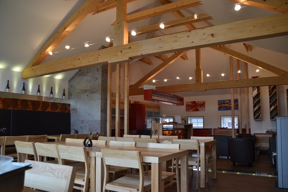 Ein Verkostungsraum mit viel Holz sowie Tischen und Stühlen.