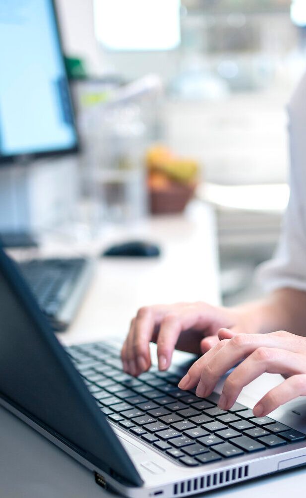 In einer modernen Umgebung wird Gesundheit großgeschrieben. Die ruhige Atmosphäre und die engagierte Fachkraft am Laptop vermitteln ein Gefühl von Sicherheit und Wohlbefinden. Hier wird Vorsorge ernst genommen und die Gesundheit der Patienten steht im Mittelpunkt.