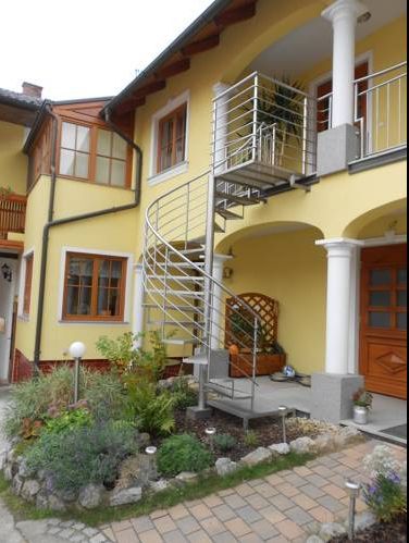Gelbes Haus mit Wendeltreppe und Garten.