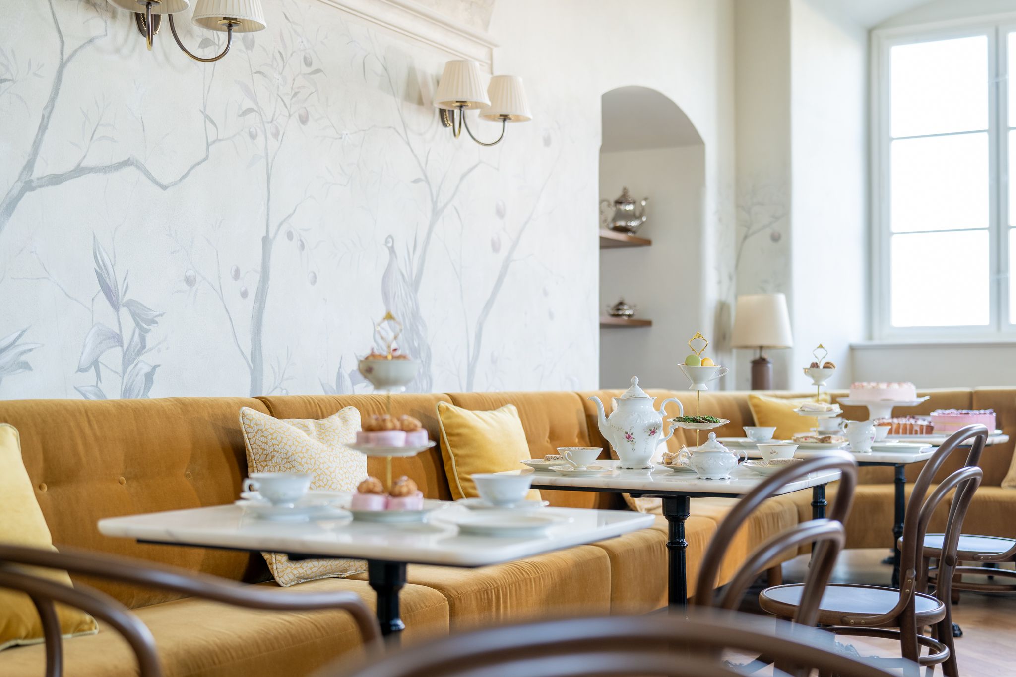 Café Arkadenhof, Schloss Hof, gelbe Sitzbänke, Tische und Stühle