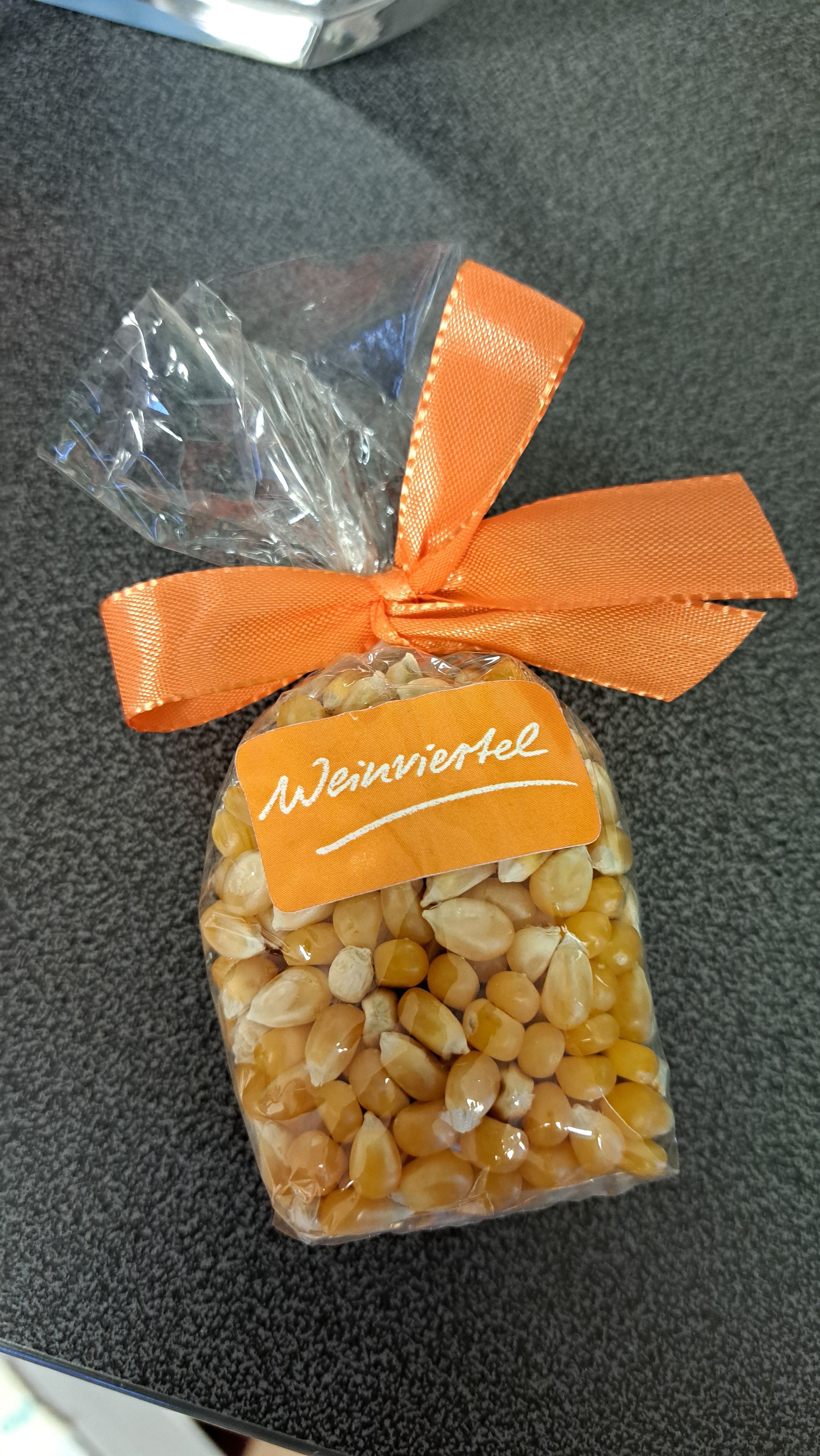 Ein Sackerl mit Maiskörner inkl. orangem Aufkleber mit Weinviertel-Logo.