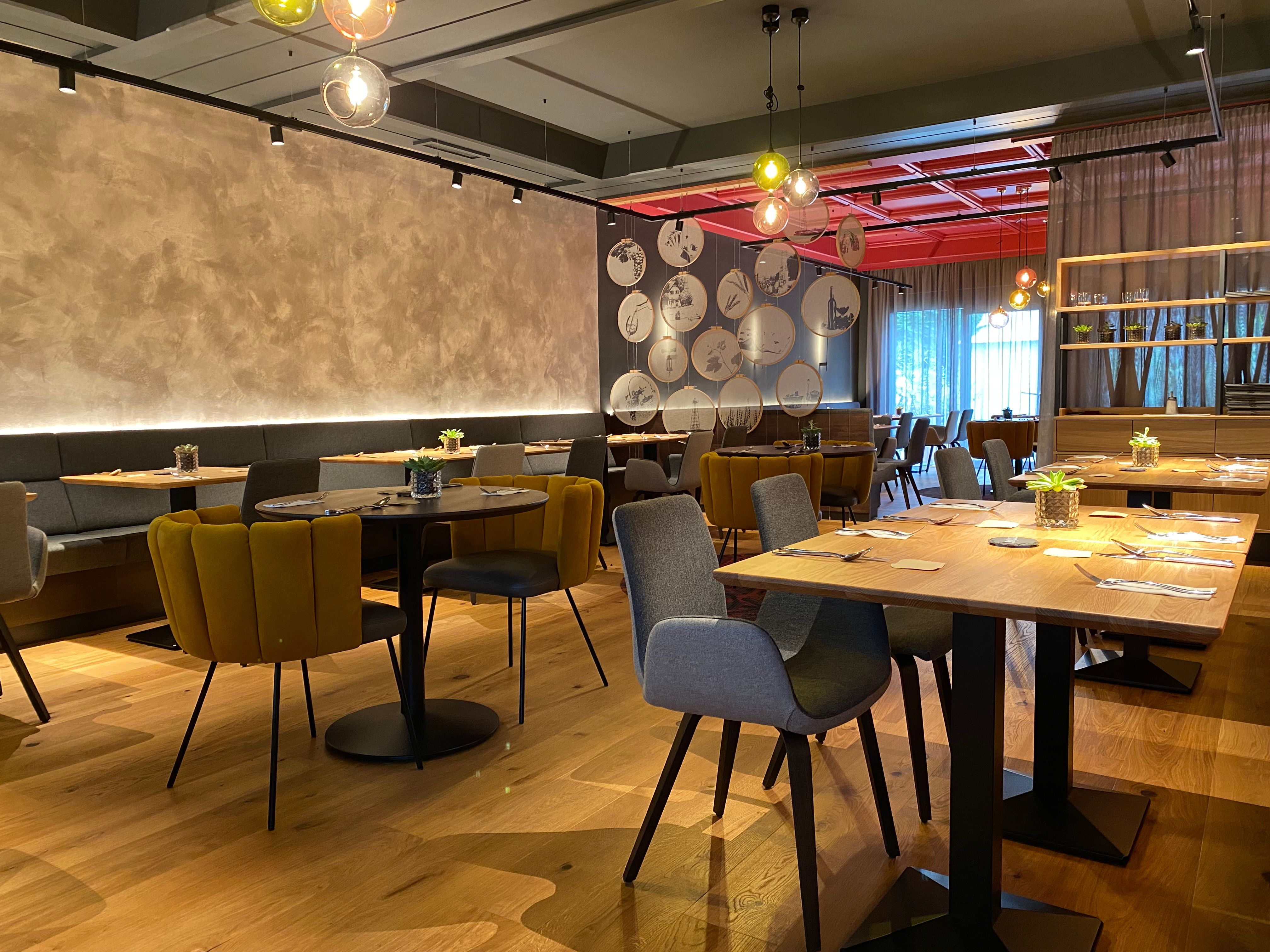 Innenansicht eines modernen Hotel-Restaurants mit stilvoller Einrichtung und warmem Licht.