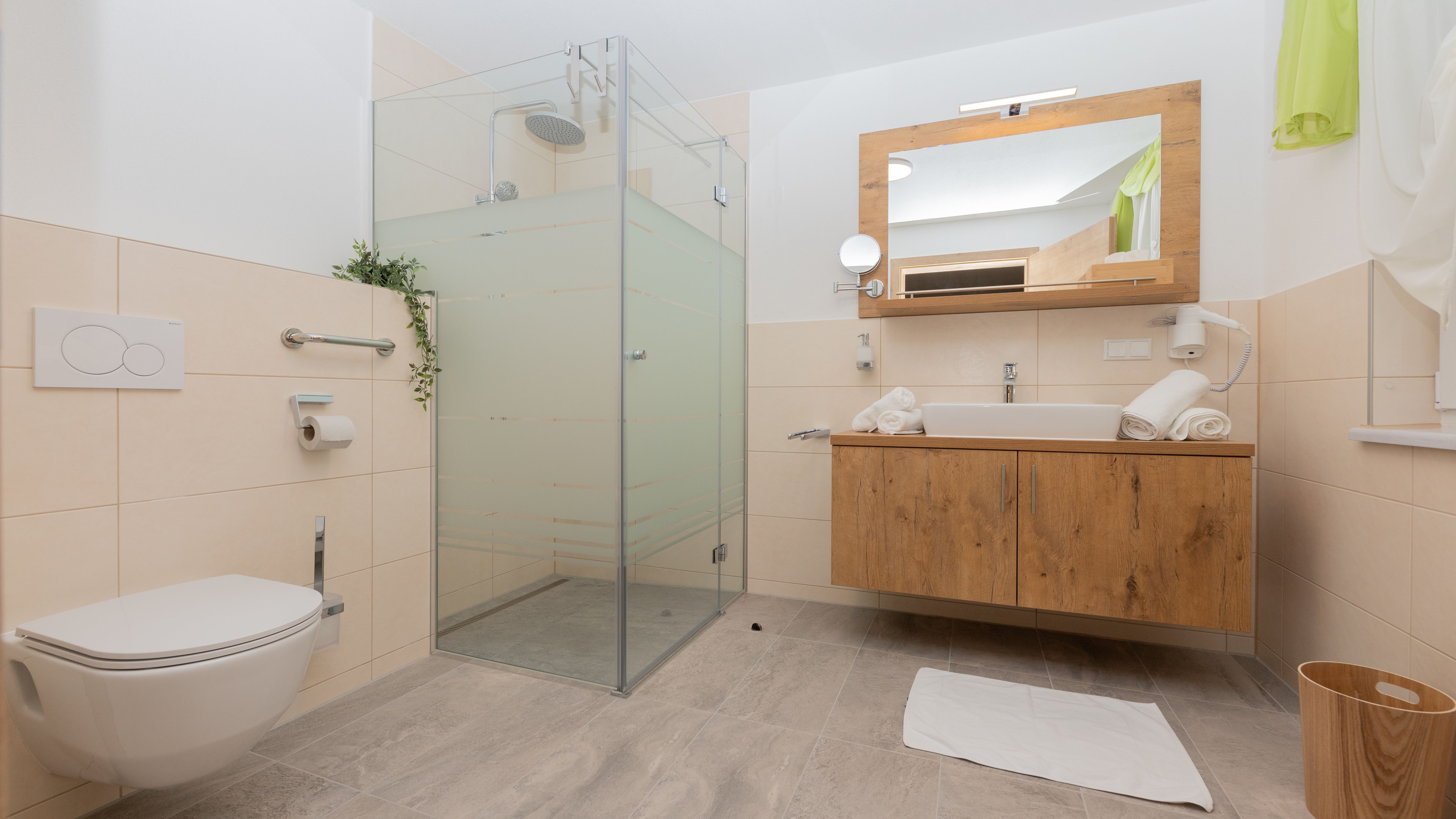 Modernes Badezimmer mit Dusche, Waschbecken und Toilette.
