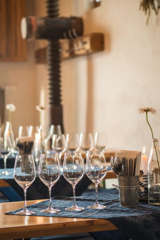 Table with wine glasses and candles in a cozy room.