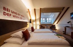 In einem stilvoll eingerichteten Zimmer mit warmen Holztönen und sanften Lichtakzenten lädt die gemütliche Atmosphäre zum Entspannen ein. Die großen Fenster bieten einen Blick auf die malerische Umgebung, während die geschmackvolle Dekoration die regionale Gastfreundschaft widerspiegelt.
