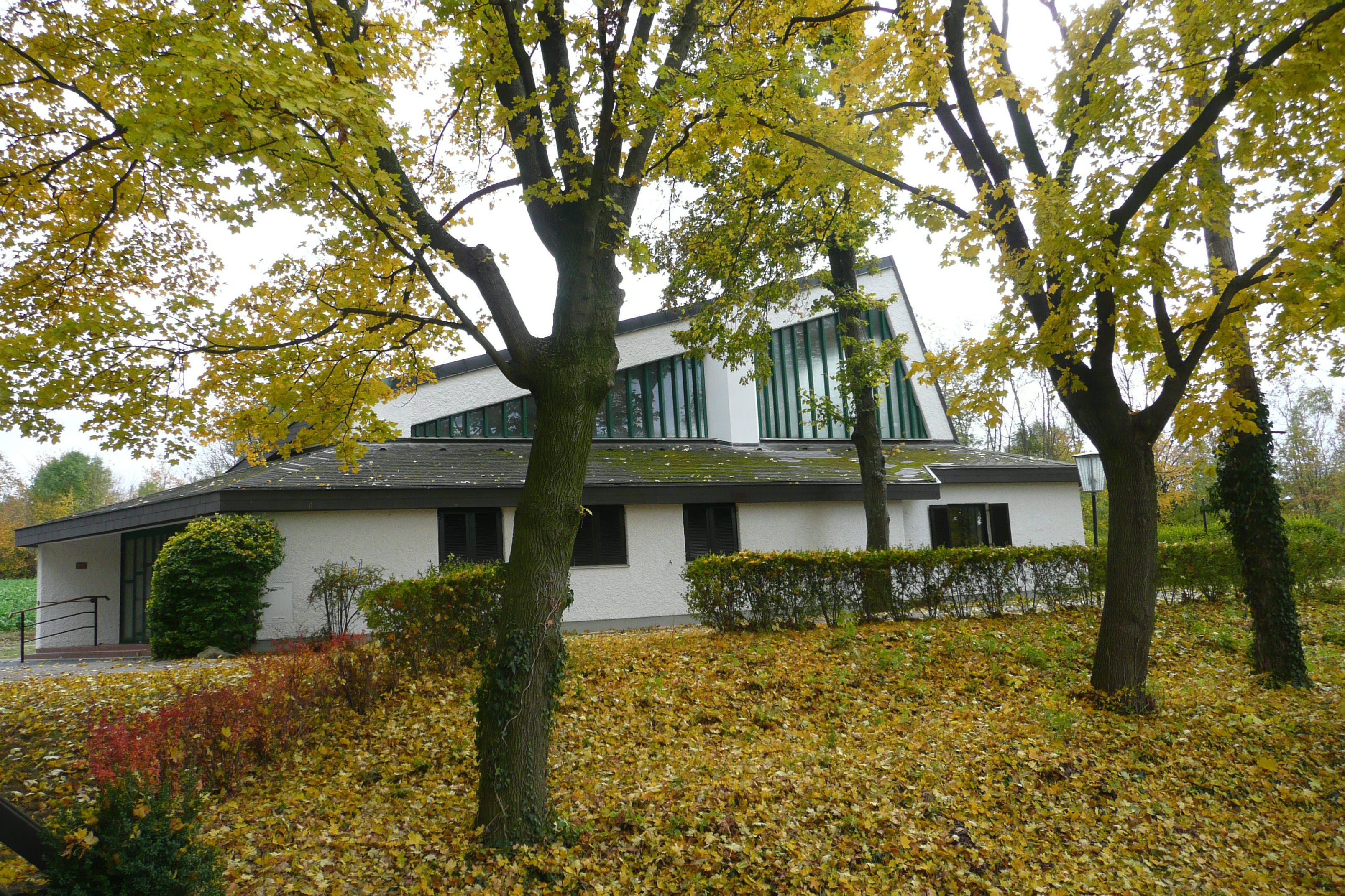 Kirche Maria Rast in Mistelbach umgeben von herbstlichen Bäumen.