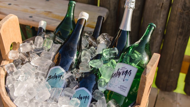 Mehrere Weinflaschen in einem Holzk&uuml;bel mit Eis.