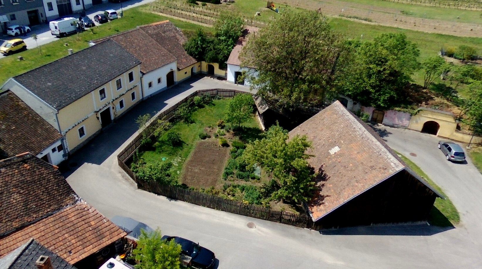 Luftaufnahme eines Bauernhofs mit Garten und umliegenden Gebäuden in Deinzendorf.