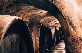 Ein alter Weinkeller mit großen Holzfässern an den Wänden.