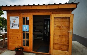 Kleines Holzgebäude mit Schildern des Weinguts Zöhrer und für frische Eier.