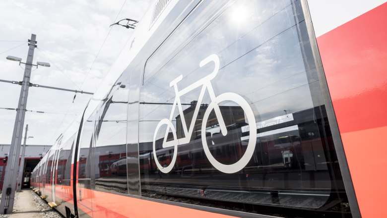 Close-up of a red train with a bicycle symbol on the window.