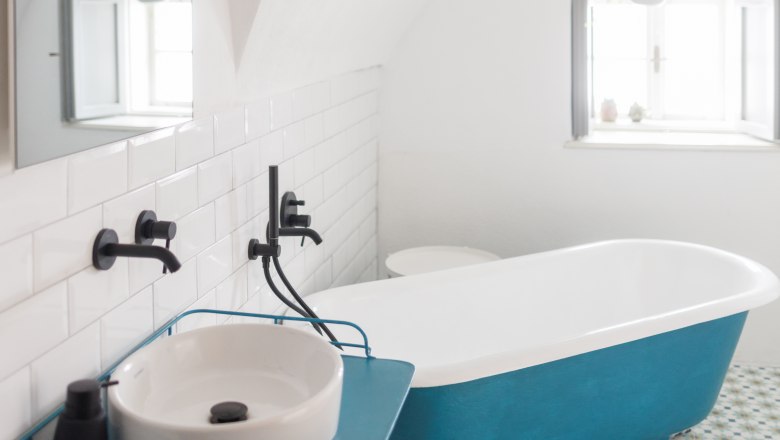 Modernes Badezimmer mit blauer Badewanne und Waschbecken.