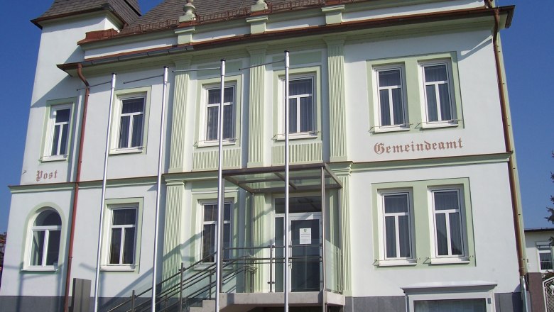 Gemeindeamt Untersiebenbrunn mit Treppe und Fahnenmasten vor dem Gebäude.