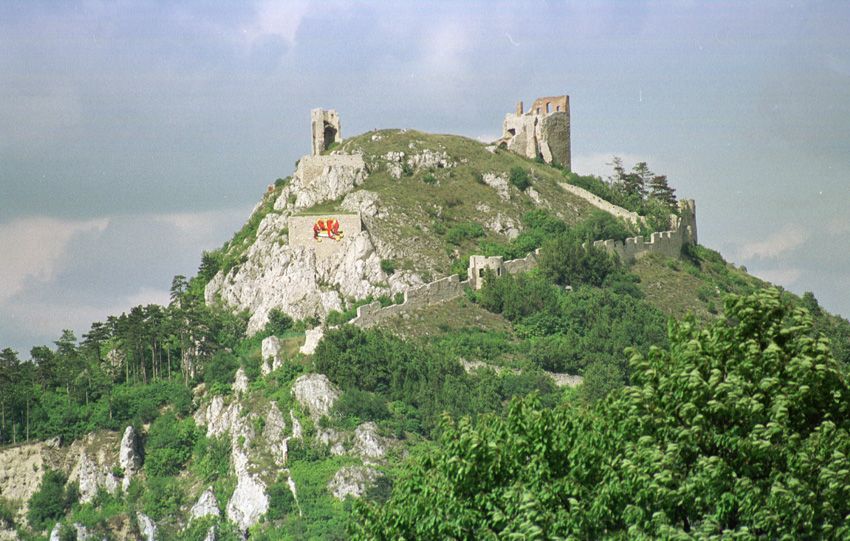 Ruinen der Burgruine Staatz auf einem Hügel mit grüner Vegetation.