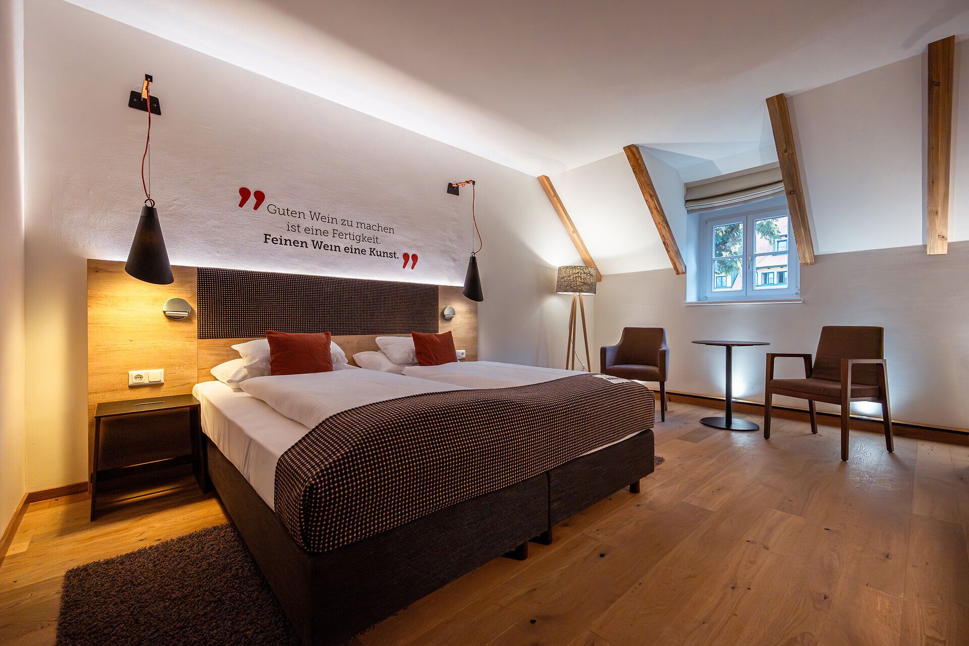 In einem stilvoll eingerichteten Zimmer mit einem gemütlichen Doppelbett und warmen Holzelementen lädt die Atmosphäre zum Entspannen ein. Die sanften Farben und das harmonische Design schaffen einen perfekten Rückzugsort, um die Schönheit der Umgebung zu genießen.