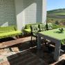 Terrace with green furniture and view of fields.
