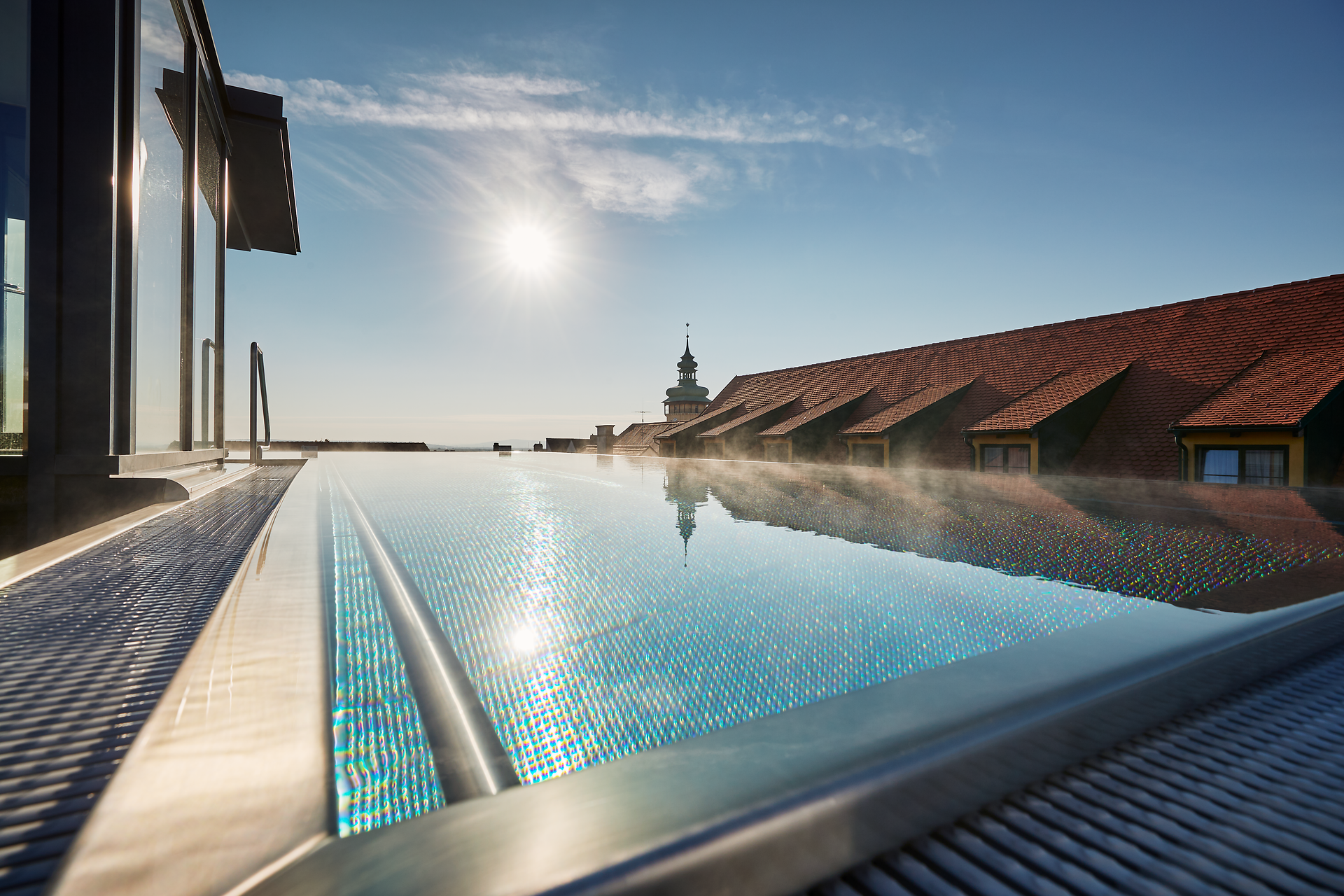 Genießen Sie den atemberaubenden Blick über die sanften Hügel des Weinviertels, während die Sonne am Horizont aufgeht. Der glitzernde Pool lädt dazu ein, sich zu entspannen und die friedliche Atmosphäre dieser malerischen Umgebung zu erleben.