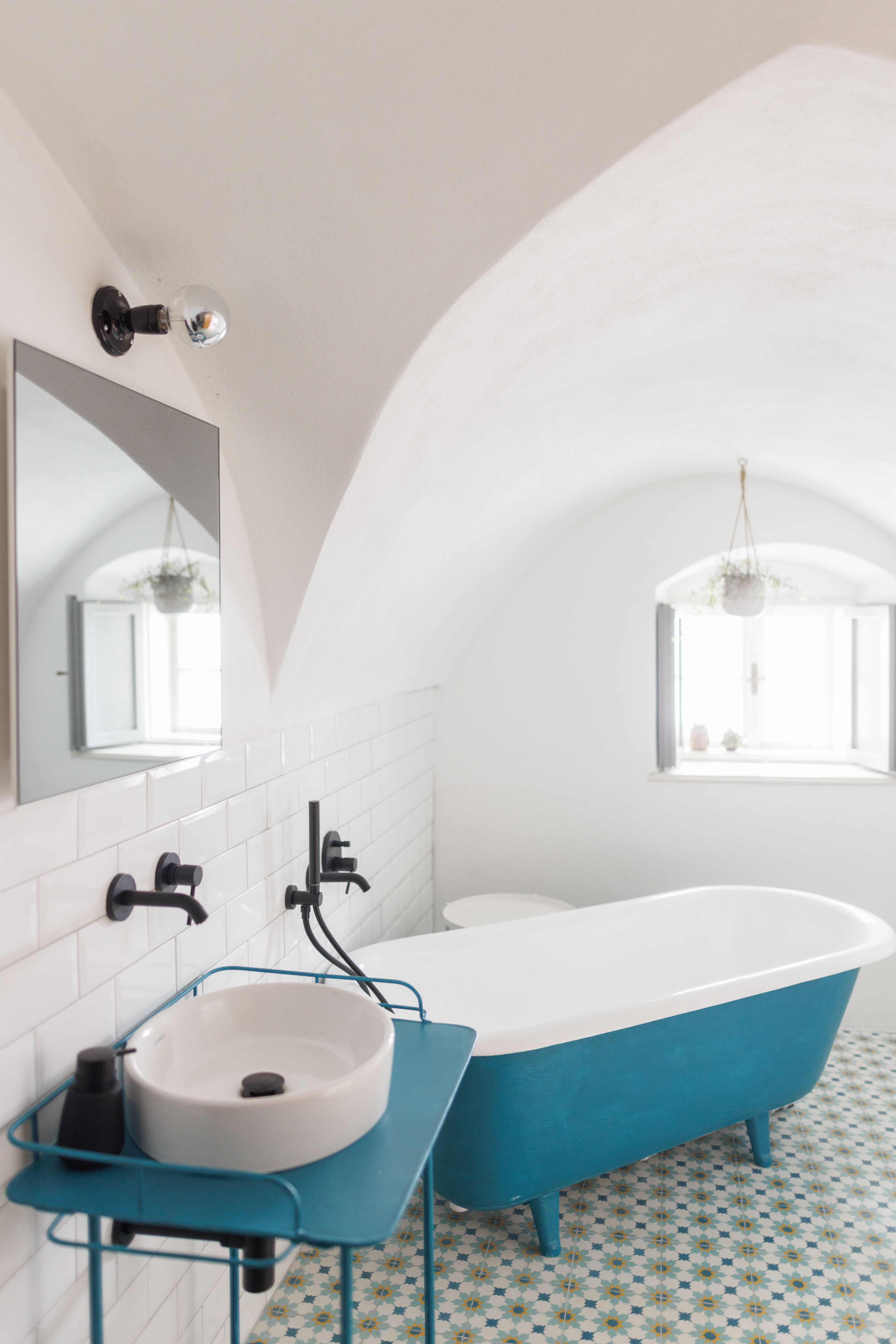 Modernes Badezimmer mit blauer Badewanne und Waschbecken.