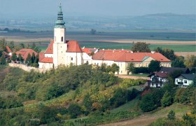 Luftbild der Pfarrkirche St. Agatha auf einem Hügel mit umliegenden Gebäuden und Landschaft.