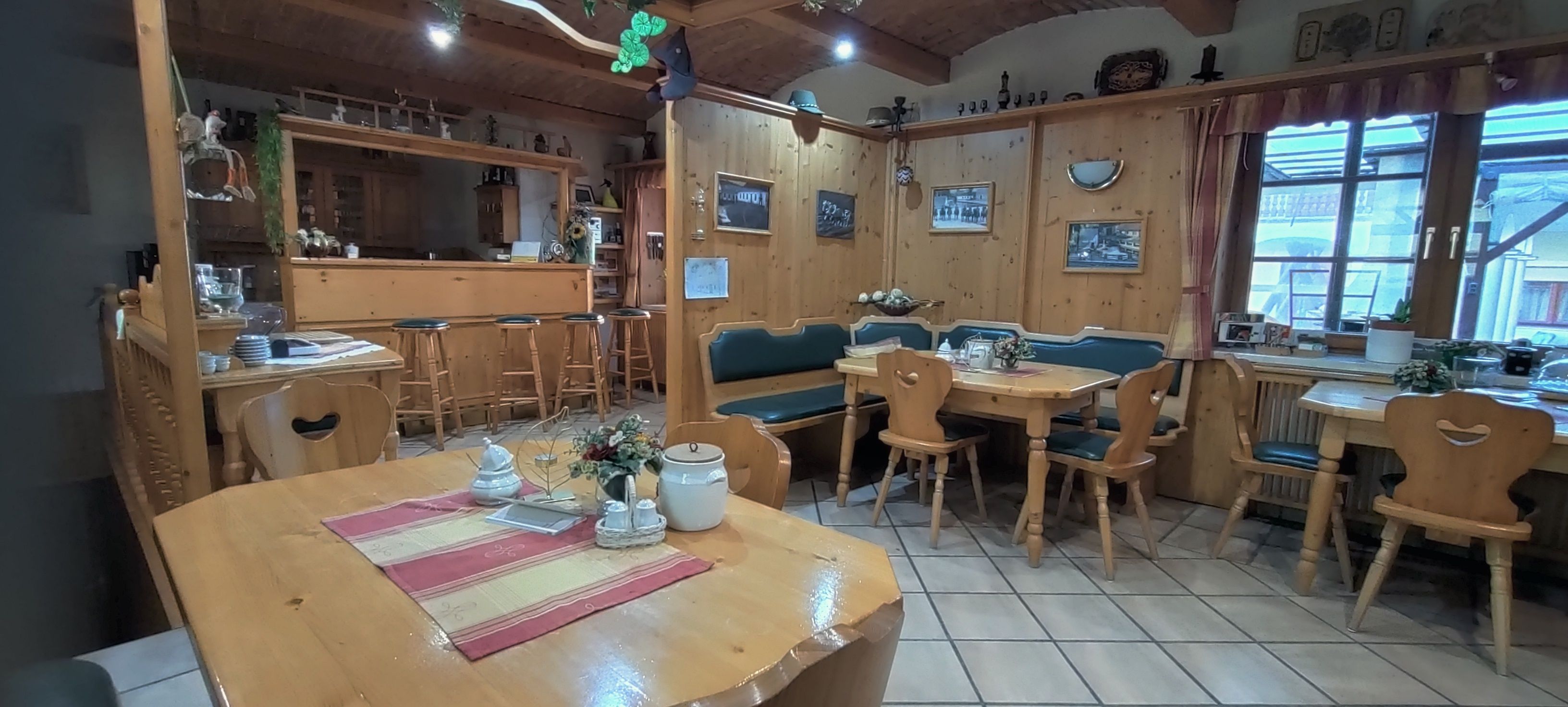 Gemütlicher Frühstücksraum mit Holzmöbeln und Dekorationen.