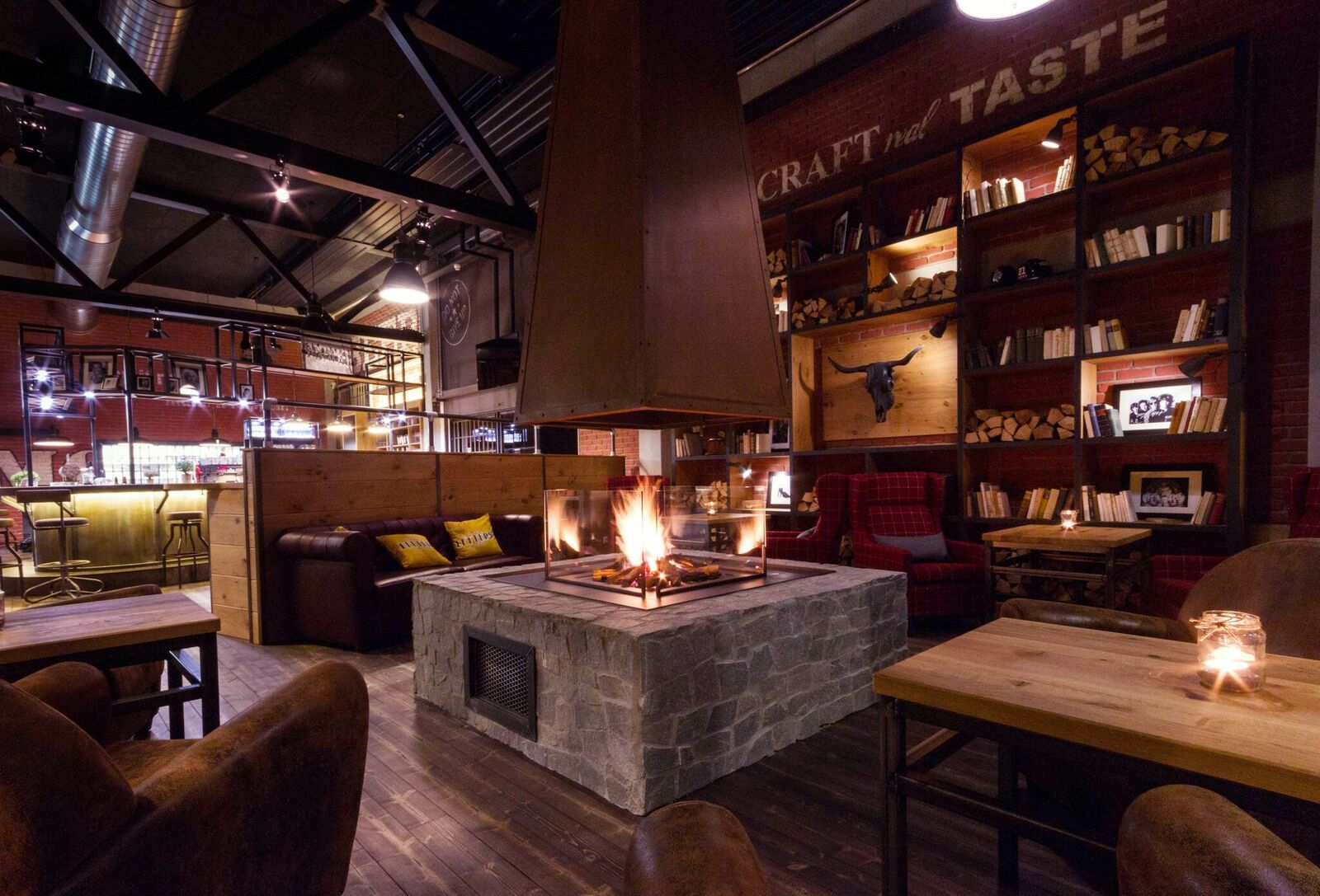 Cozy room with fireplace, wooden furniture and bookshelves.
