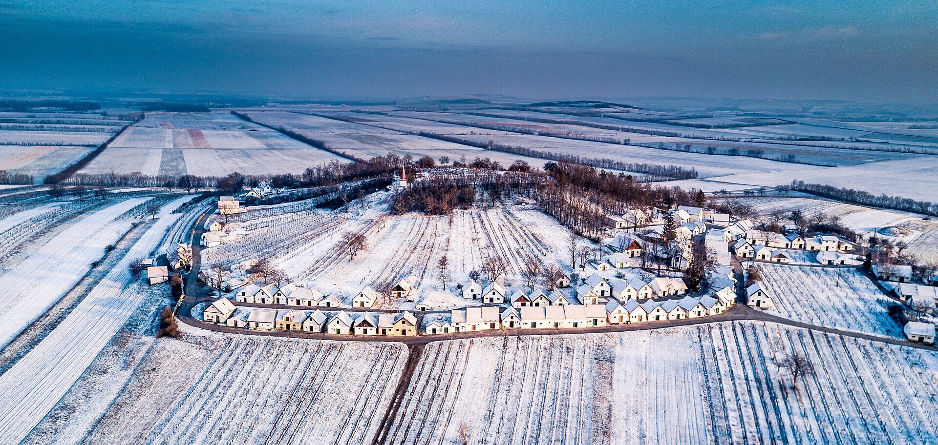 In der winterlichen Kellergasse von Wildendürnbach liegt eine friedliche Stille über den schneebedeckten Hütten. Die sanften Hügel und die glitzernde Schneedecke schaffen eine zauberhafte Kulisse, die zum Verweilen und Entdecken einlädt.