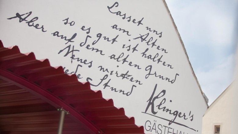 Fassade von Klinger's G&auml;stehaus mit handgeschriebener Inschrift und rotem Vordach.