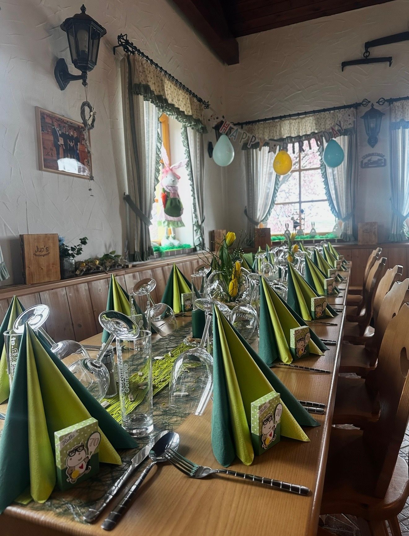 Gedeckter Tisch mit grünen Servietten und grünem Tischschmuck