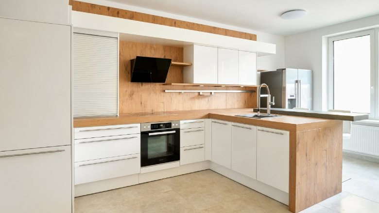 Moderne Küche mit Holz- und Weißtönen, Herd, Spüle und großem Fenster.