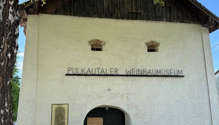 Eingang des Pulkautaler Weinbaumuseums mit alten landwirtschaftlichen Ger&auml;ten davor.