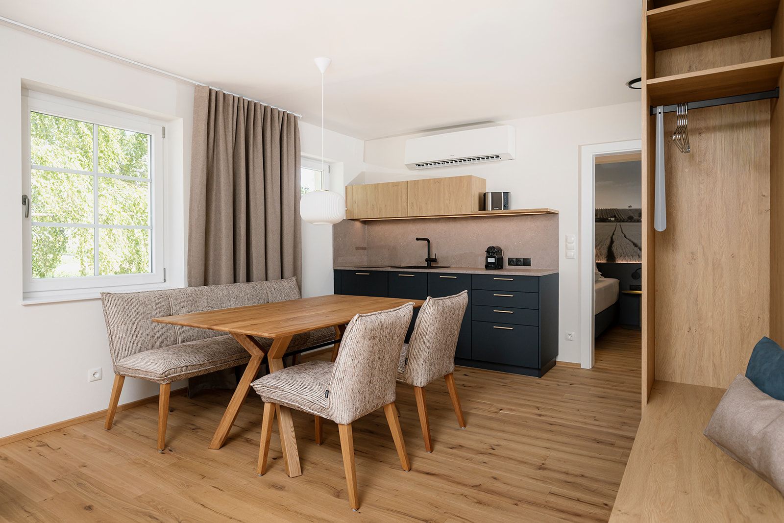 Moderne Küche und Essbereich mit Holzmöbeln und Parkettboden.