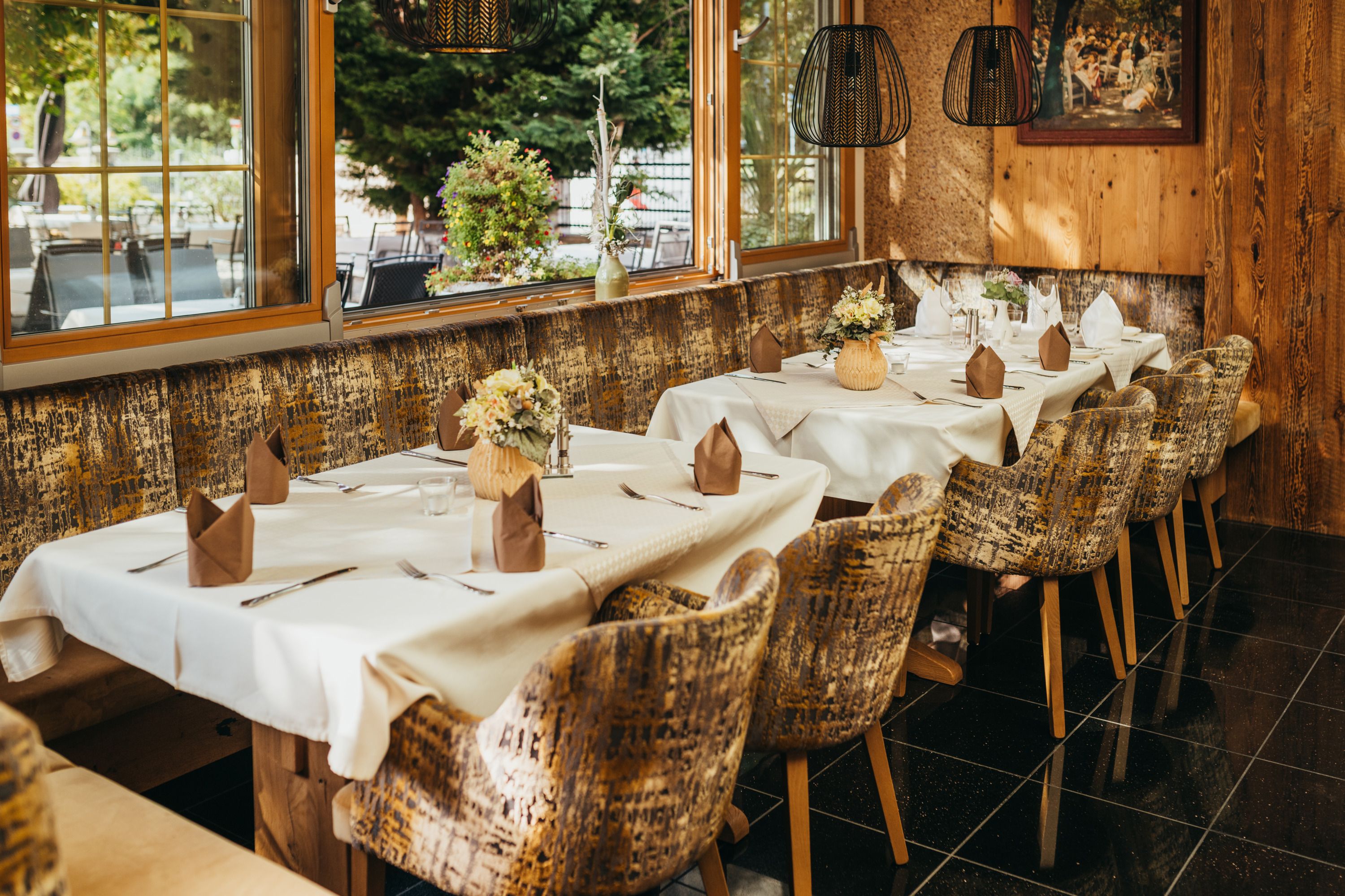 Gemütliches Restaurant mit gedeckten Tischen, Blumen und rustikalem Ambiente.