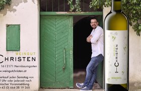 Ein Mann lehnt an einer gr&uuml;nen T&uuml;r neben einer Weinflasche mit dem Etikett 'Weingut Christen'.