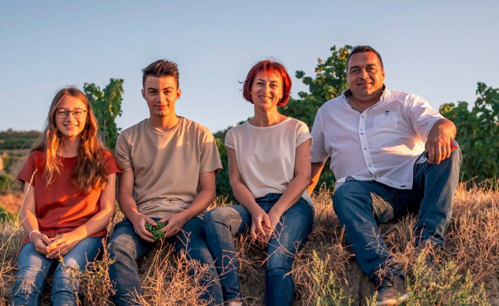 Vier Personen sitzen auf einem Feld im Sonnenuntergang.