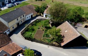 Luftaufnahme eines Bauernhofs mit Garten und umliegenden Gebäuden in Deinzendorf.